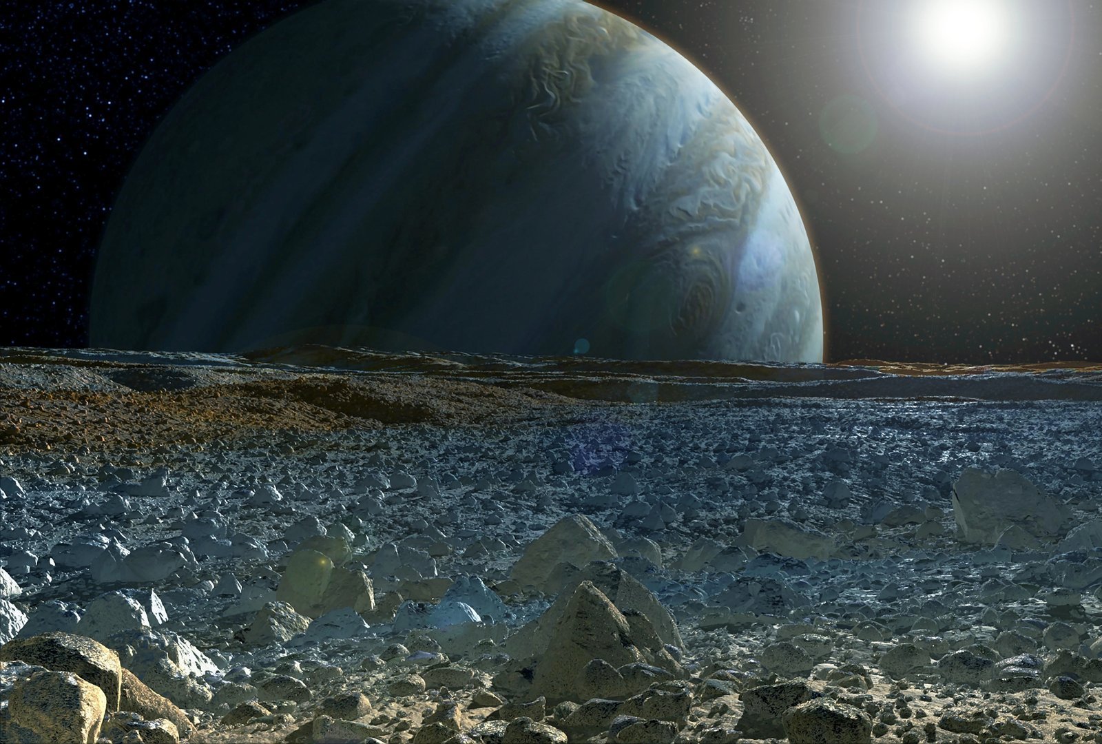 Jupiter looming over the rocky, icy surface of one of its moons, with the sun low on the horizon
